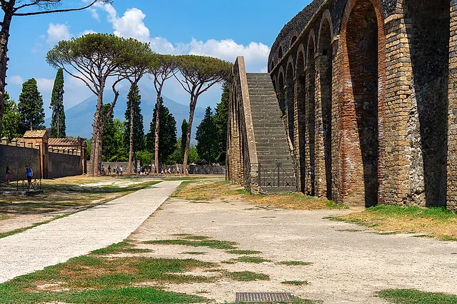 The exterior arches and stairway of the Pompeii amphitheatre with umbrella pines