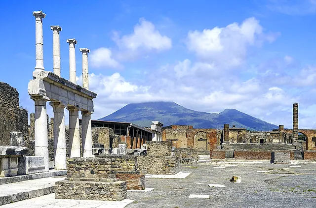 The Forum of Pompeii with the white colonnade in the foreground and Mount Vesuvius rising behind the ruins
