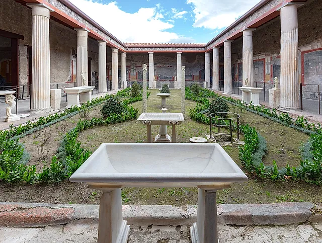 The peristyle garden of the House of the Vettii in Pompeii with marble basins and a colonnade