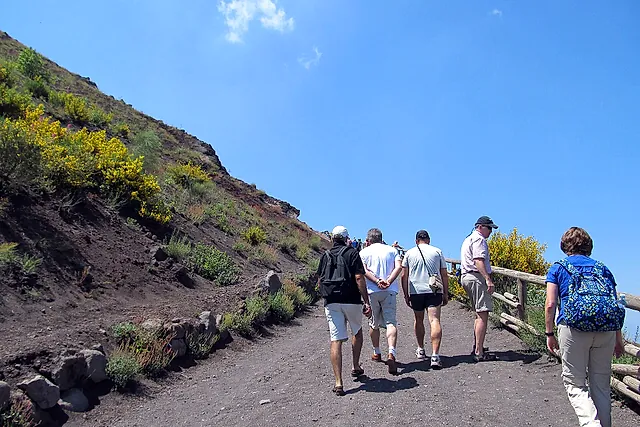 Hikers climbing the gravel path up to the summit crater of Vesuvius